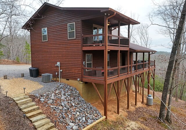 back of property featuring crawl space, cooling unit, and a wooden deck