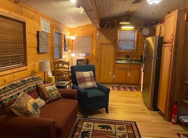 living area with light hardwood / wood-style floors, wooden ceiling, lofted ceiling, and wooden walls