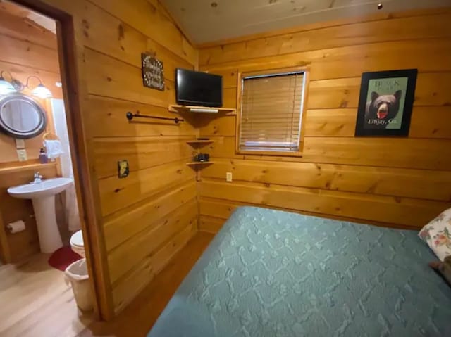 bedroom featuring wood walls and hardwood / wood-style floors