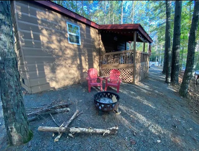 exterior space featuring an outdoor fire pit and a deck