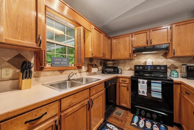 kitchen featuring sink, hardwood / wood-style flooring, black appliances, decorative backsplash, and vaulted ceiling