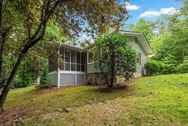 view of side of property featuring a yard and a sunroom