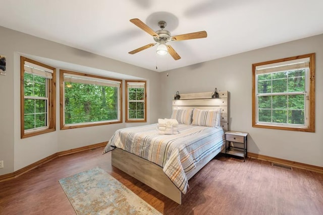 bedroom with dark hardwood / wood-style floors and ceiling fan