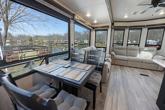 sunroom / solarium featuring visible vents and a ceiling fan