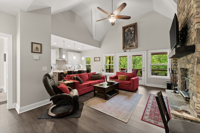 457 Celie Ann Seabolt Rd, Cleveland, GA 30528 - living room featuring a stone fireplace, ceiling fan, high vaulted ceiling, dark wood-style flooring, and baseboards