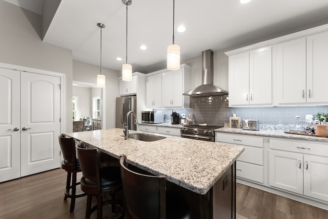 457 Celie Ann Seabolt Rd, Cleveland, GA 30528 - kitchen with wall chimney range hood, appliances with stainless steel finishes, a sink, an island with sink, and tasteful backsplash