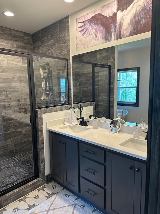 full bathroom with double vanity, recessed lighting, a shower stall, and a sink