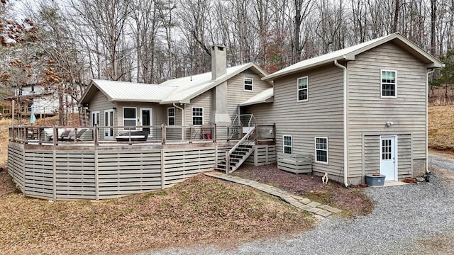 rear view of property featuring stairs, a chimney, and a wooden deck