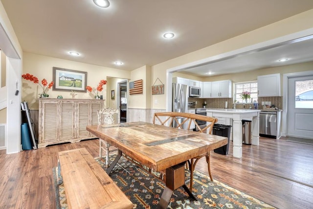 dining area with light wood finished floors and recessed lighting