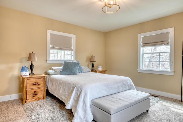 bedroom with baseboards and light colored carpet