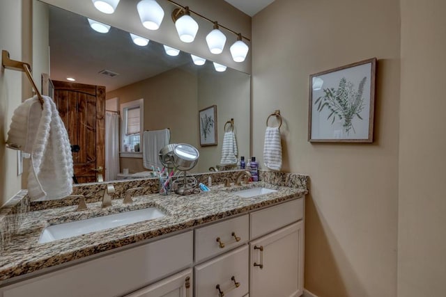 bathroom featuring double vanity, a sink, and visible vents