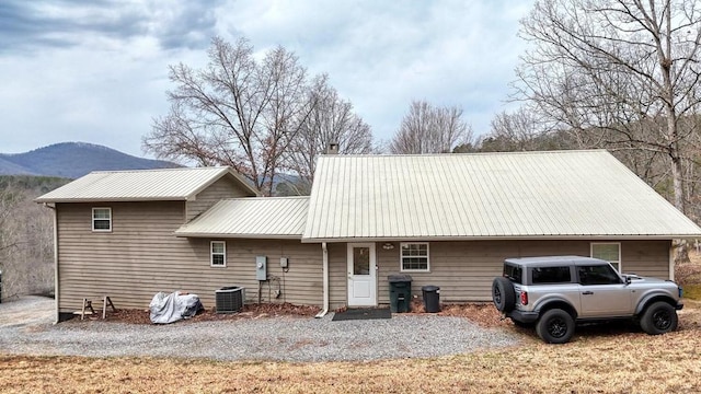 back of house featuring metal roof, central AC, and a mountain view