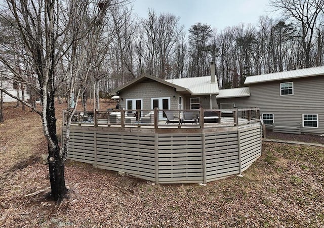 rear view of house featuring metal roof and a deck