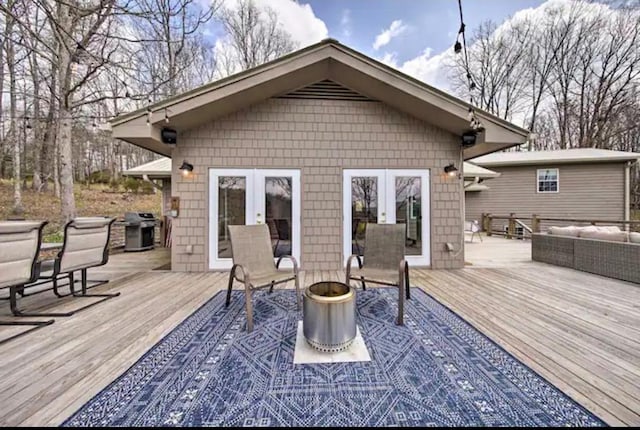 wooden terrace featuring french doors, a grill, and an outdoor living space