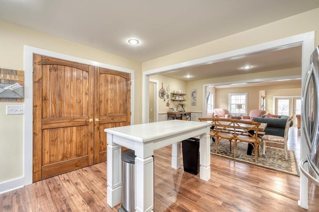 kitchen with open floor plan, light countertops, light wood-type flooring, and freestanding refrigerator