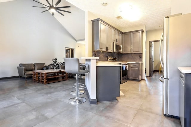 3065 NW Kings Rd, Kennesaw, GA 30144 - kitchen with appliances with stainless steel finishes, a breakfast bar, decorative backsplash, light countertops, and lofted ceiling