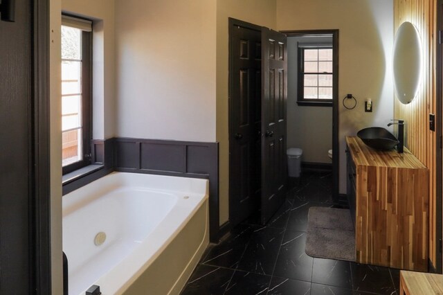 3065 NW Kings Rd, Kennesaw, GA 30144 - full bathroom with a bath, toilet, vanity, and healthy amount of natural light