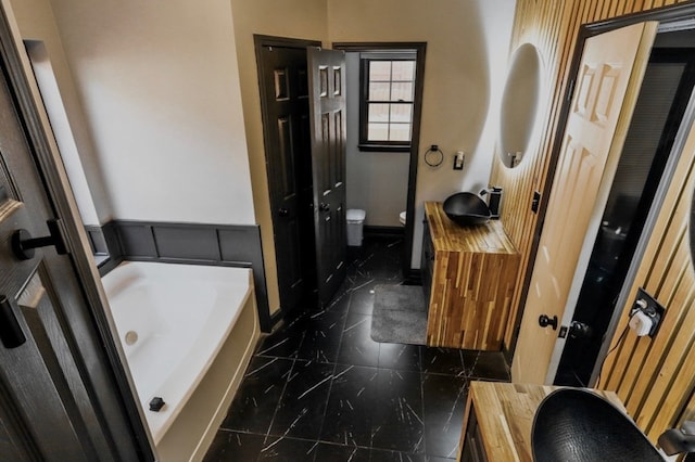 3065 NW Kings Rd, Kennesaw, GA 30144 - bathroom with marble finish floors, toilet, a garden tub, and vanity
