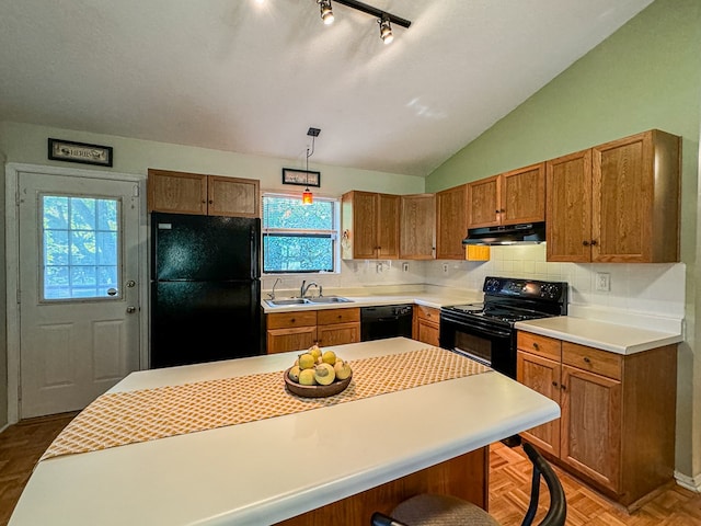 kitchen featuring parquet flooring, hanging light fixtures, vaulted ceiling, black appliances, and sink