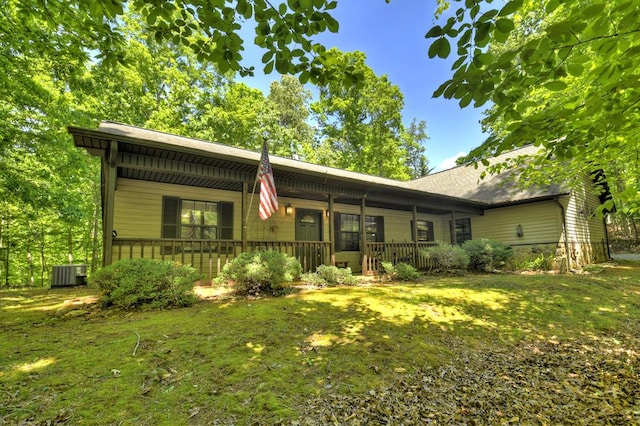 view of front of house featuring a porch, a front lawn, and central AC unit