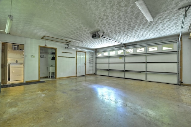 garage with washer / clothes dryer, a garage door opener, and baseboards