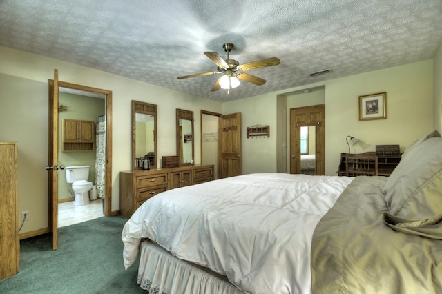 carpeted bedroom with ensuite bathroom, ceiling fan, a textured ceiling, and baseboards