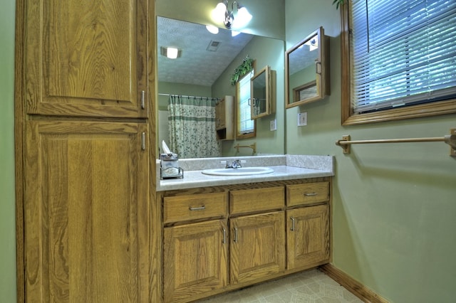 bathroom featuring vanity, a textured ceiling, and curtained shower