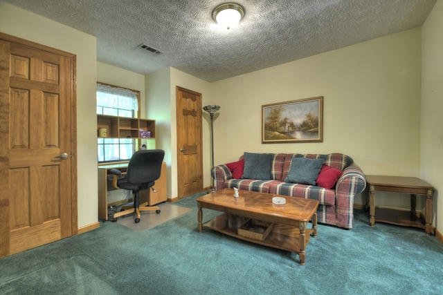 living area featuring a desk, carpet flooring, and a textured ceiling