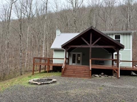 5575 Rainbow Springs Rd, Franklin, NC 28734 - rear view of house featuring a wooded view, a fire pit, a deck, and a chimney