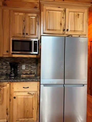 5575 Rainbow Springs Rd, Franklin, NC 28734 - kitchen with appliances with stainless steel finishes, tasteful backsplash, dark stone countertops, and wood finished floors