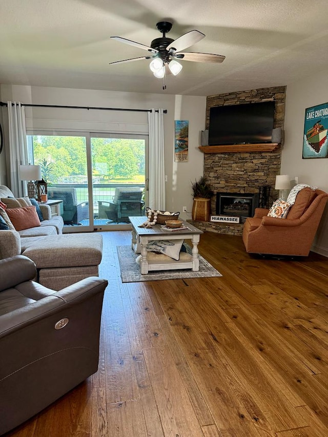 209B N Berrong St, Hiawassee, GA 30546 - living area featuring ceiling fan, a stone fireplace, and hardwood / wood-style floors