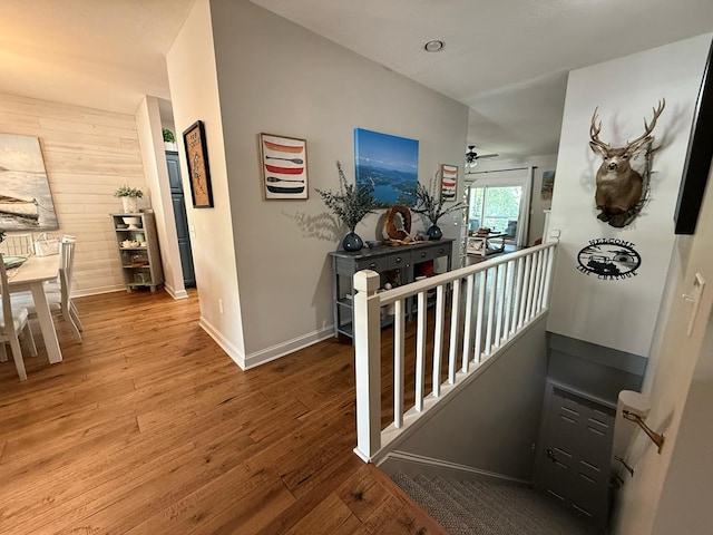209B N Berrong St, Hiawassee, GA 30546 - hall with wooden walls, wood finished floors, and an upstairs landing