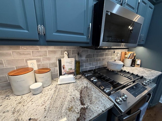 209B N Berrong St, Hiawassee, GA 30546 - kitchen featuring blue cabinetry, stainless steel appliances, decorative backsplash, and light stone countertops