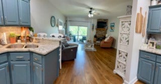 209B N Berrong St, Hiawassee, GA 30546 - kitchen featuring blue cabinetry, open floor plan, a peninsula, and wood finished floors