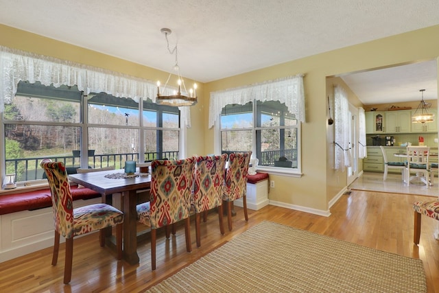 dining area featuring hardwood / wood-style flooring, a textured ceiling, and a chandelier