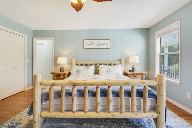 bedroom with a textured ceiling, wood-type flooring, a closet, and ceiling fan