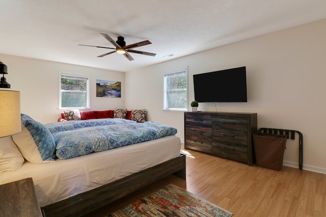 bedroom featuring multiple windows, light wood-type flooring, and ceiling fan