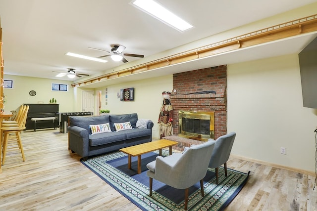 living room with light hardwood / wood-style flooring, a fireplace, and ceiling fan