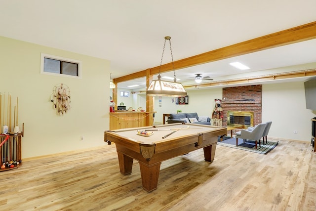 recreation room featuring beam ceiling, billiards, ceiling fan, hardwood / wood-style flooring, and a brick fireplace