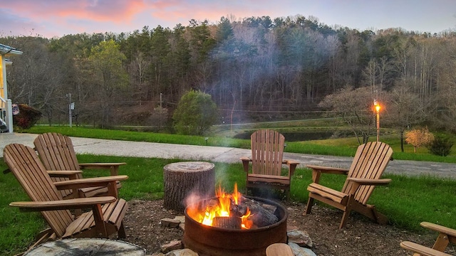 exterior space with an outdoor fire pit and a lawn