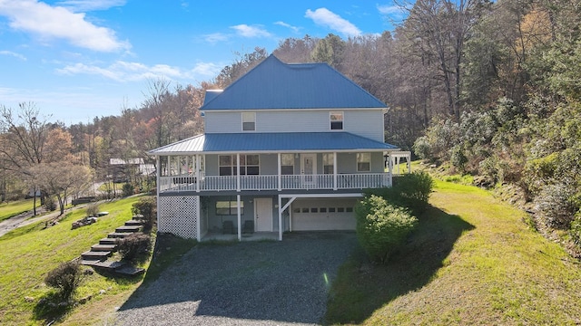 exterior space featuring a porch, a front lawn, and a garage