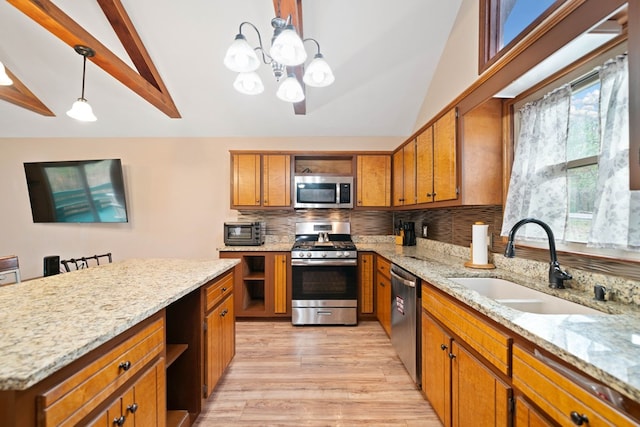 kitchen featuring hanging light fixtures, stainless steel appliances, sink, light stone counters, and lofted ceiling with beams