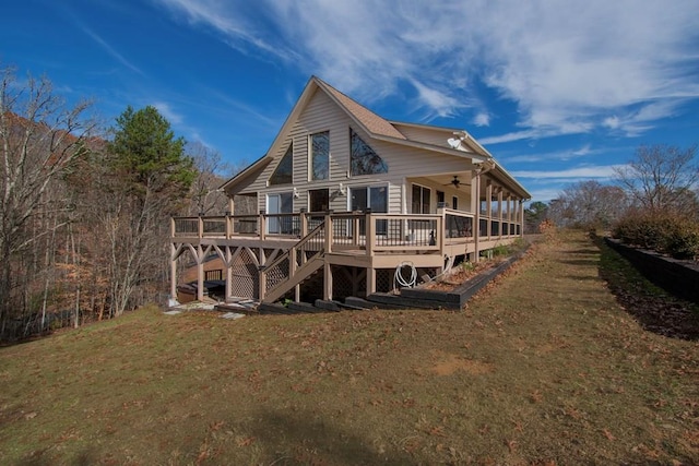 back of property with a lawn, ceiling fan, and a deck