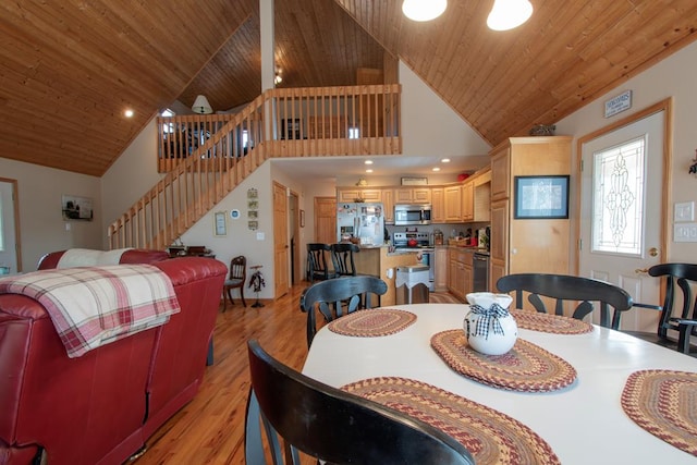 dining space with light hardwood / wood-style flooring, high vaulted ceiling, and wood ceiling