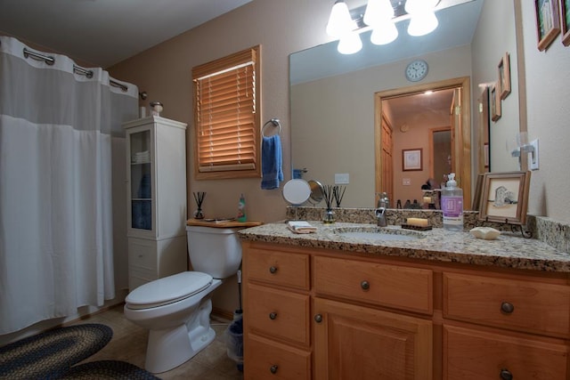 bathroom featuring curtained shower, tile patterned flooring, vanity, and toilet