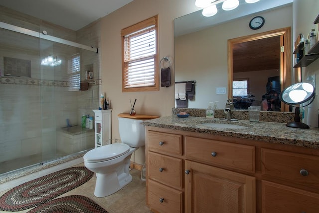 bathroom featuring tile patterned floors, vanity, an enclosed shower, and toilet