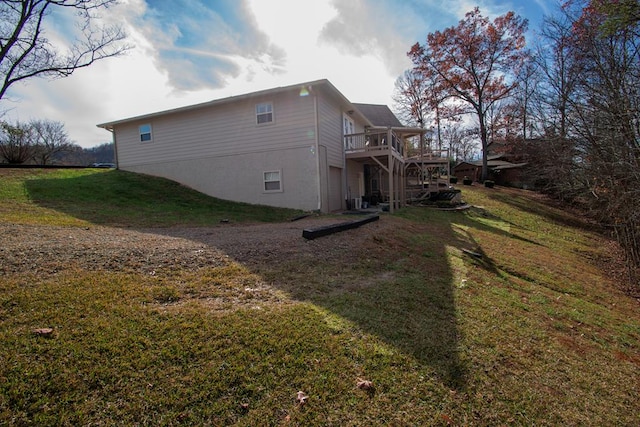 view of home's exterior with a wooden deck and a yard