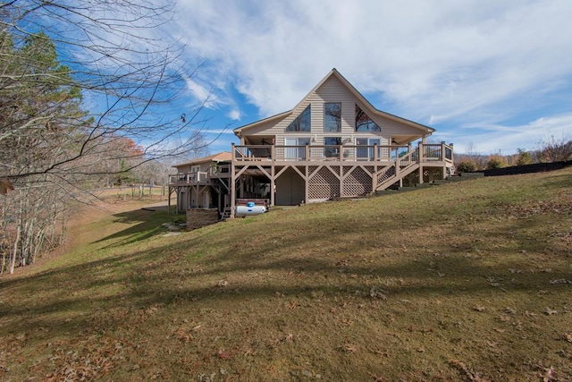 rear view of house featuring a lawn and a wooden deck