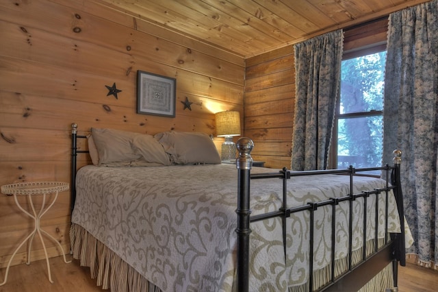 bedroom with wooden walls, hardwood / wood-style floors, and wooden ceiling