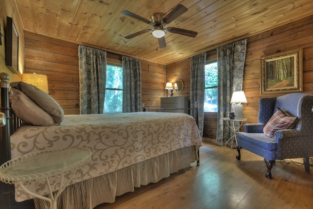 bedroom with wooden walls, ceiling fan, wooden ceiling, and hardwood / wood-style floors